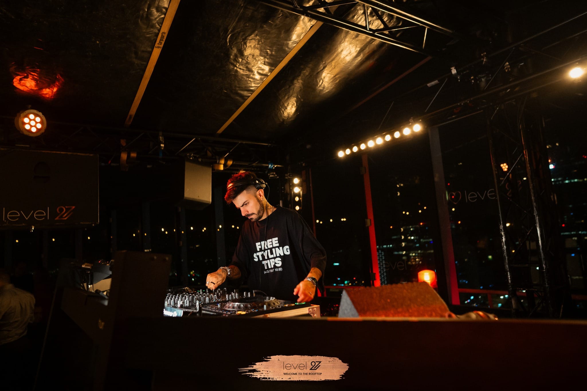 Hugo Cantarra prowadzi imprezę na dachu w klubie muzycznym w Warszawie, miksując muzykę na konsolecie