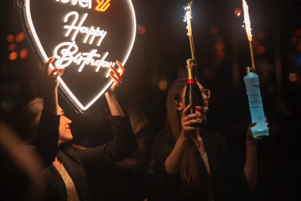 Obsługa level 27 z racami i neonem Happy Birthday jako przykład tego, jak wygląda nowoczesna kultura klubowa w Polsce